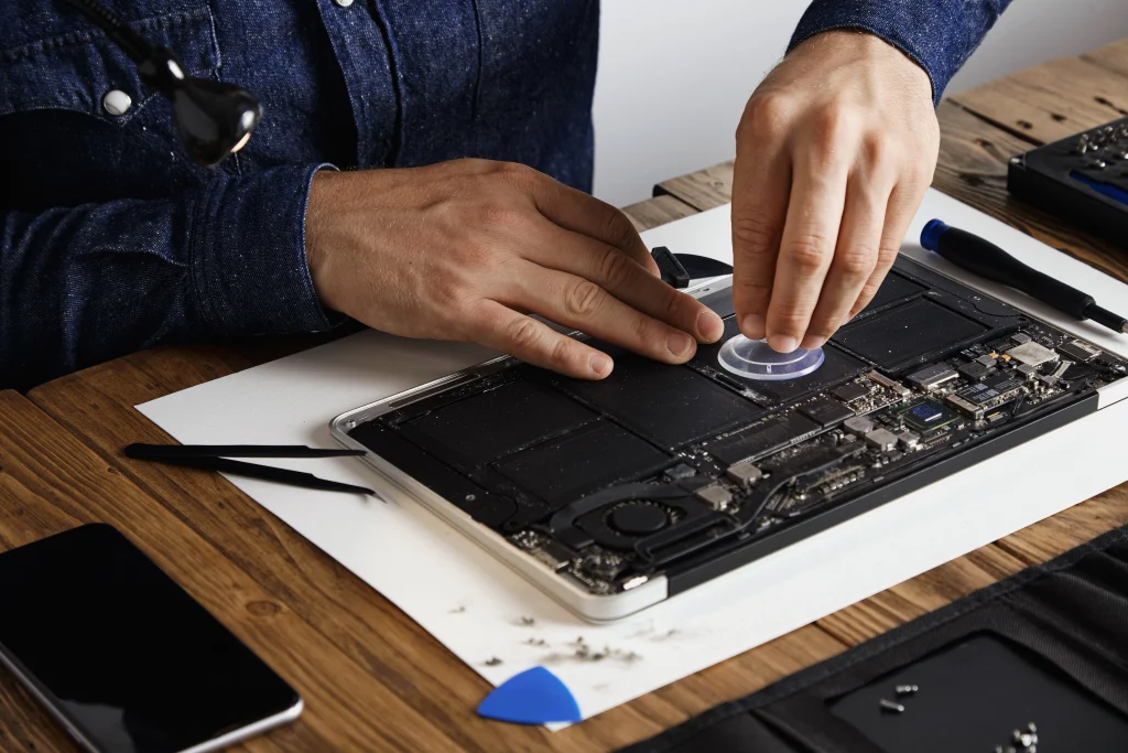 Técnico reemplazando la batería de un portátil durante un mantenimiento